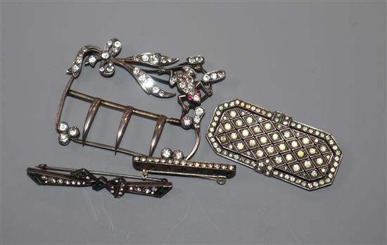 A paste set white metal buckle and three other paste set brooches, largest 63mm.